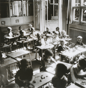 876938 Afbeelding van een groep kinderen aan tafeltjes op de RK Kleuterschool (Waterstraat 4) in Wijk C te Utrecht, met ...